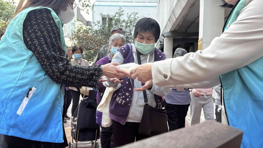 志願者將餐盒交到長者手中